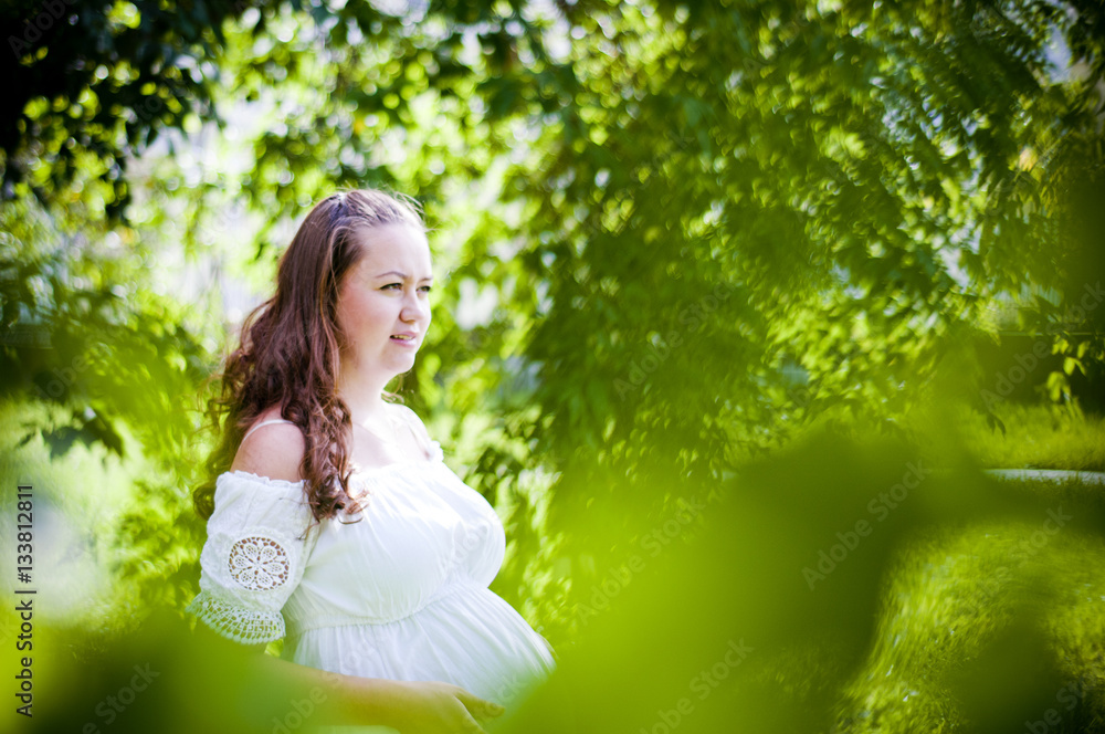 Beautiful pregnant woman relaxing outside in the park Beautiful pregnant woman relaxing outside in the park