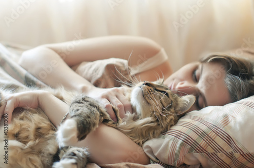 girl sleeping in bed with her cat