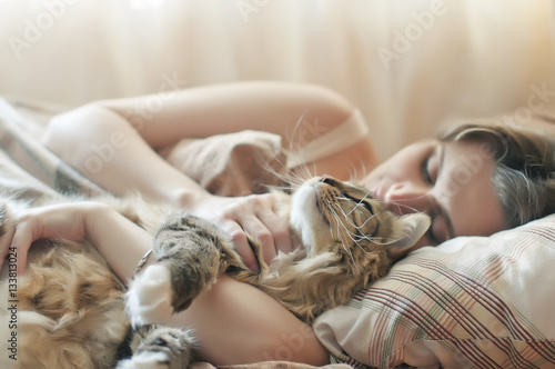 girl sleeping in bed with her cat