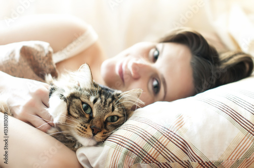 girl sleeping in bed with her cat