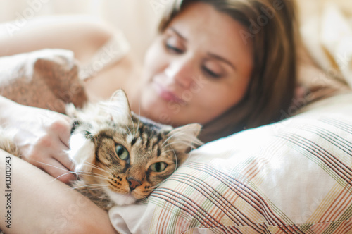 girl lying in bed with her cat