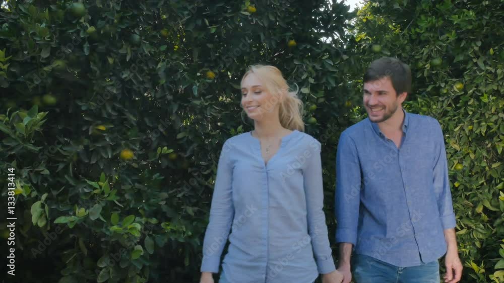 Lovely couple walking among the citrus trees on a plantation Lovely couple walking among the citrus trees on a plantation
