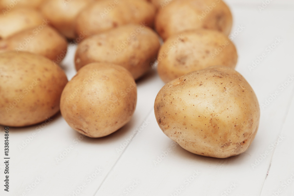 Close up of new potatoes on the white wooden table Close up of new potatoes on the white wooden table