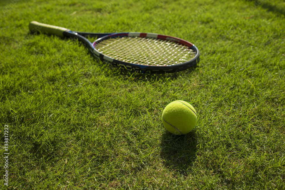 Tennis ball and racket on green grass field ground Stock Photo Adobe