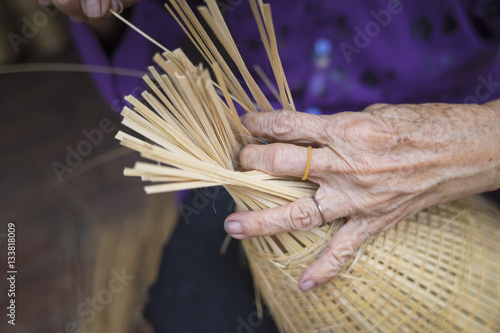 Woman hand weaving tropical bamboo fish trap in traditional crafts village in Vietnam