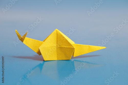   Paper origami snail isolated on a colorful background