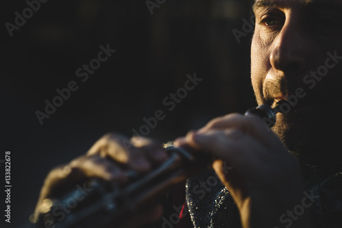 Man touching wind instrument © karrastock