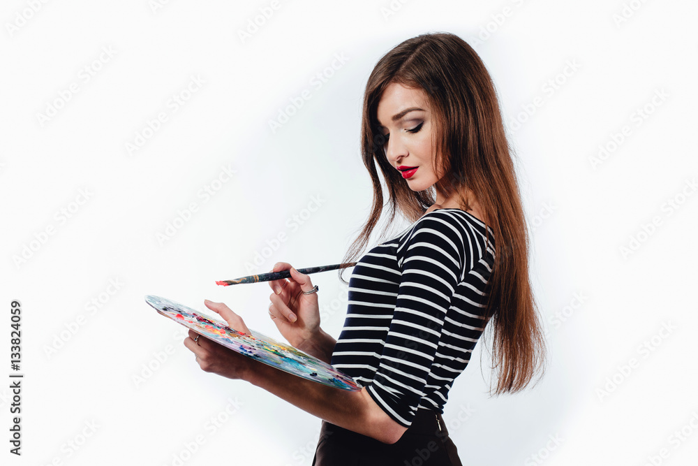 Cute beautiful girl artist holding a palette and brush in the process ...