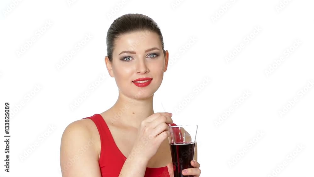 brunette woman drinking cherry juice from glass brunette woman drinking cherry juice from glass