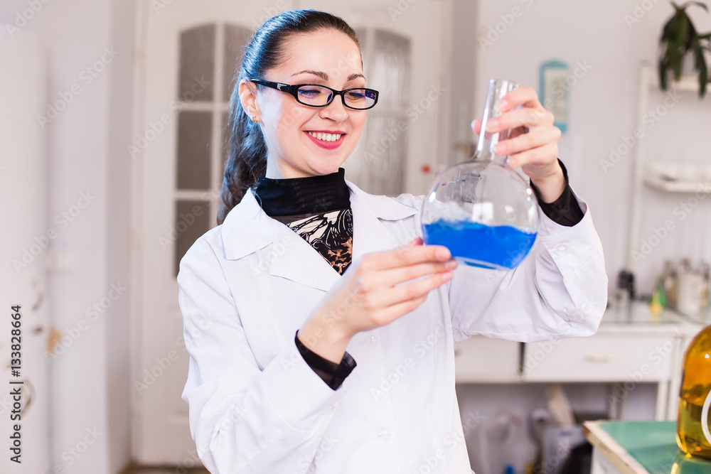 A scientist in a laboratory studying the liquid in the beaker A scientist in a laboratory studying the liquid in the beaker