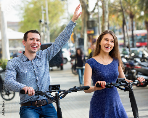 Happy young man and woman with electrkc bikes photo