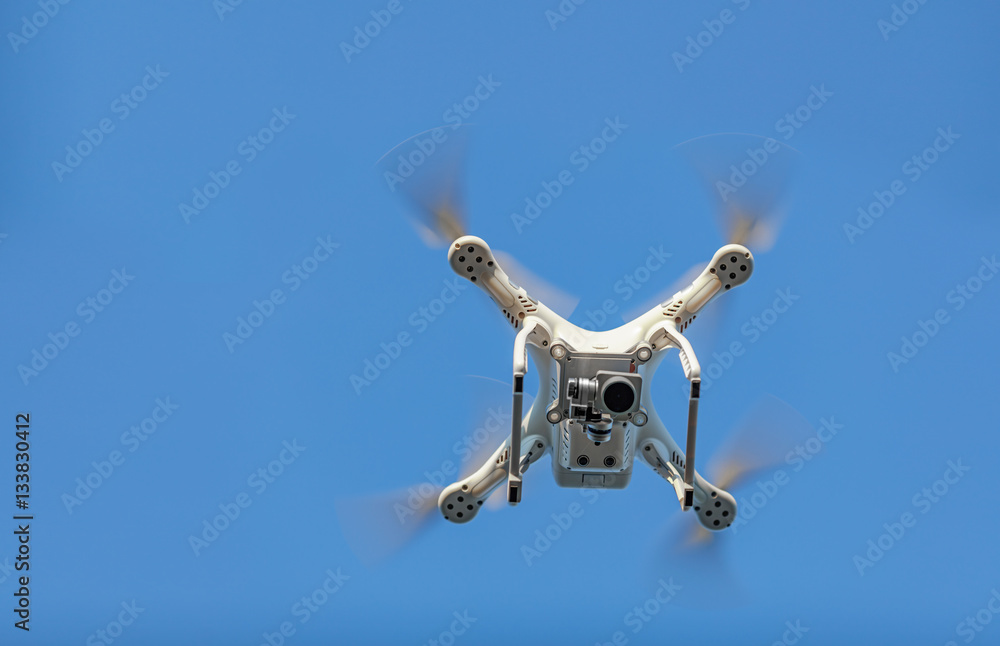 Drone is watching you. White drone quad copter with high resolut Drone is watching you. White drone quad copter with high resolut