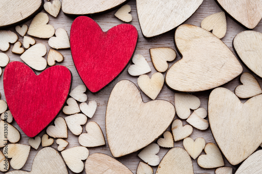 Obraz premium Wooden hearts, one red heart on the heart background.