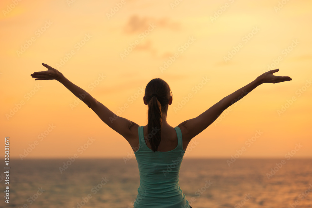 Healthy woman celebrating during a beautiful sunset. Happy and Free.

