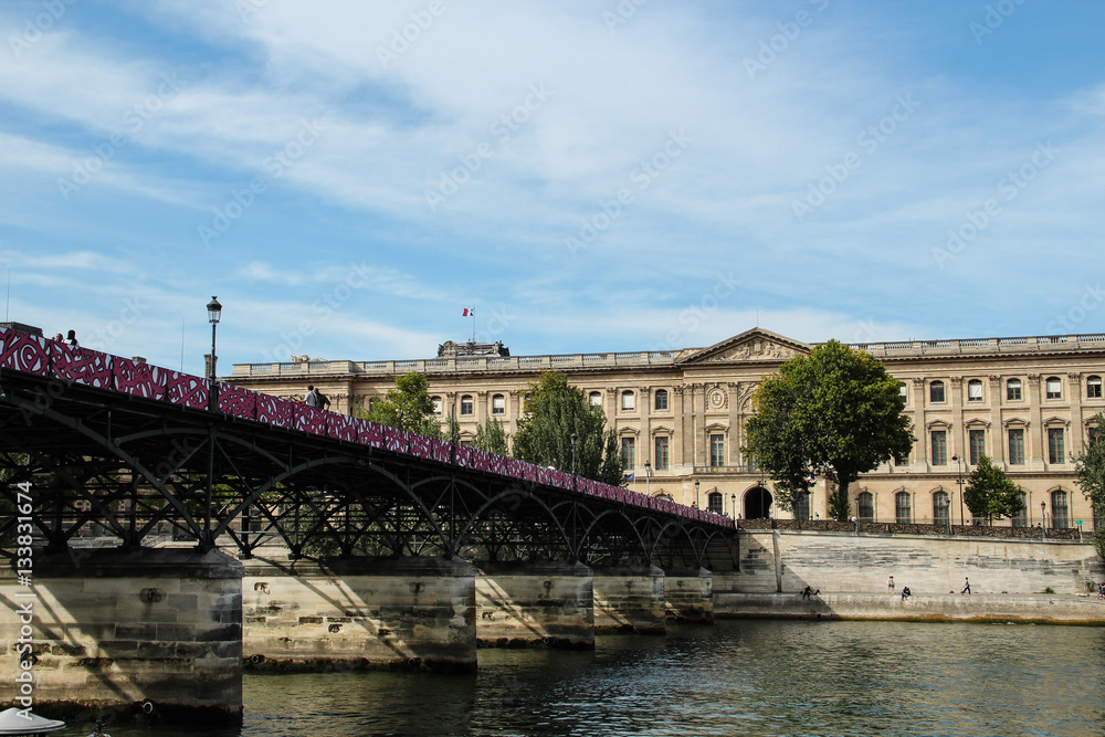 Pont des Arts across the Seine river, Louvre musum in Paris