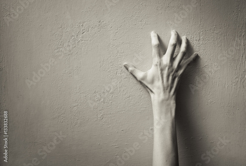 Fototapeta Hand clawing up a wall. Frustration, and anger concept.