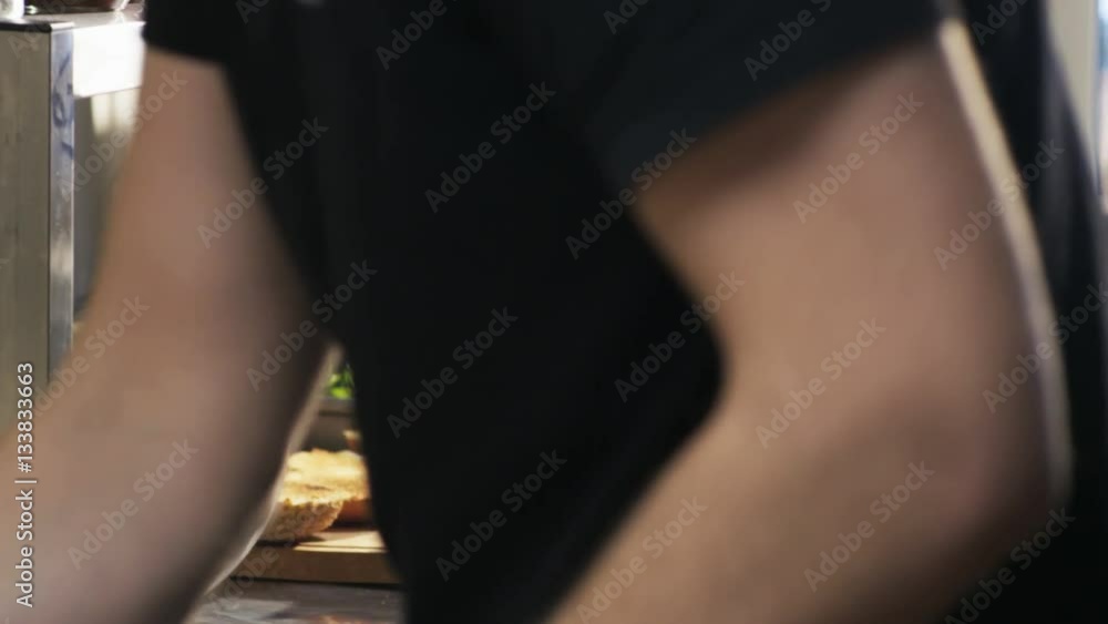 Man Putting Grilled Meat and Cheese on Bread Rolls Man Putting Grilled Meat and Cheese on Bread Rolls