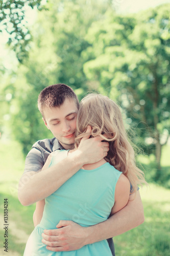 Lovely young couple in love, man embracing woman, warm feelings,