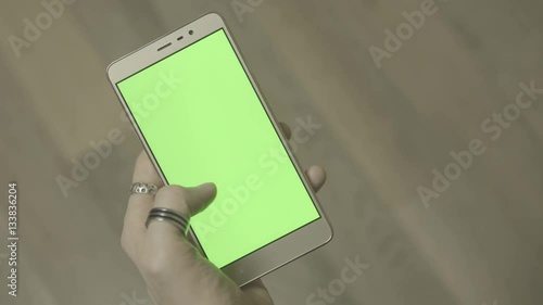 Man using smartphone with green screen. Close up shot hands with mobile, 4k ungraded footage shot in 24fps  photo