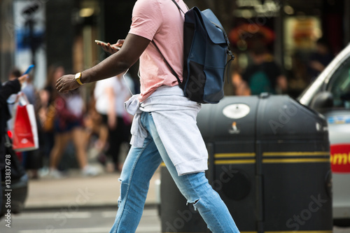 Young men walking in Oxford street, the main destination of Londoners for shopping. Modern life concept