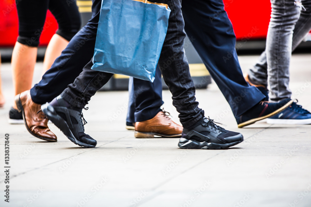 Fototapeta premium Feet of pedestrians walking on the crosswalk in Oxford street, London. Modern life, travel and shopping concept