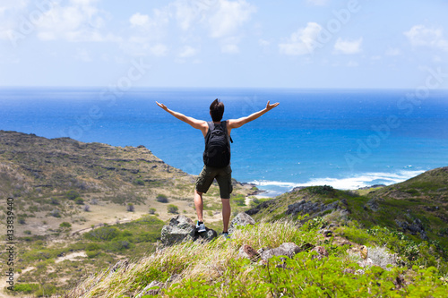 Active fit lifestyle concept. Male hiker standing on a mountain enjoying the beautiful view. 