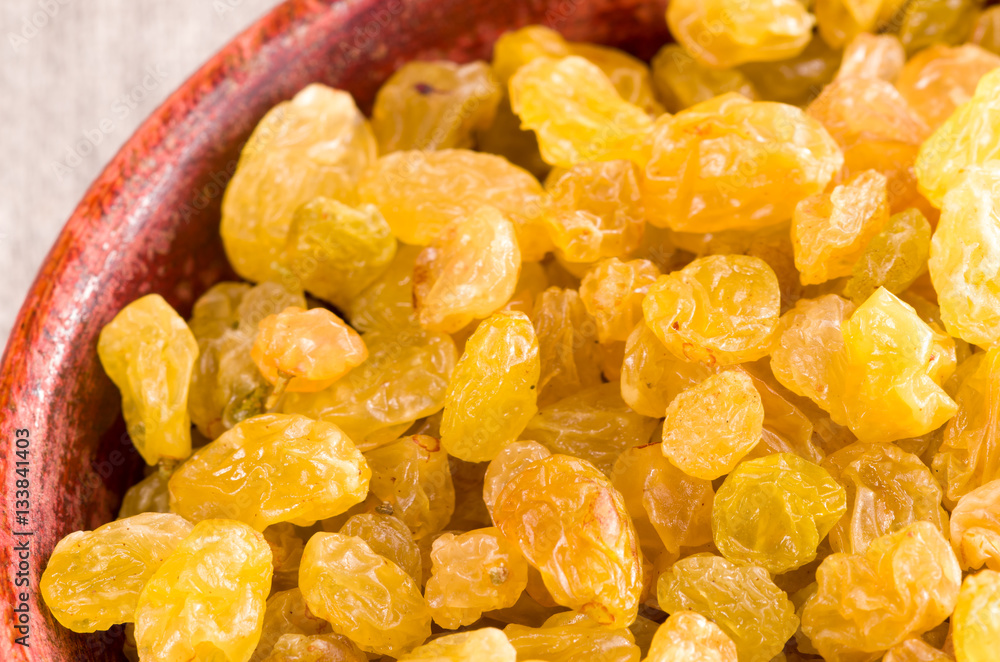 Sweet raisins in a brown wooden bowl Sweet raisins in a brown wooden bowl