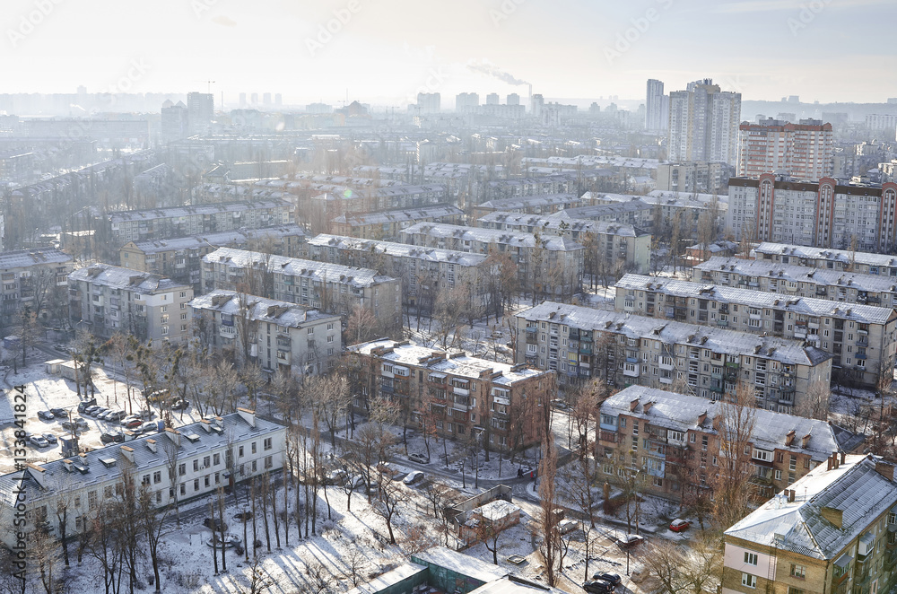 The aerial View of residential district Darnitsa in Kyiv,Ukraine in sunny winter day.View over the city rooftops with sunlight and snow.Moderns buildings at Industrial uptown,residential neighbourhood
