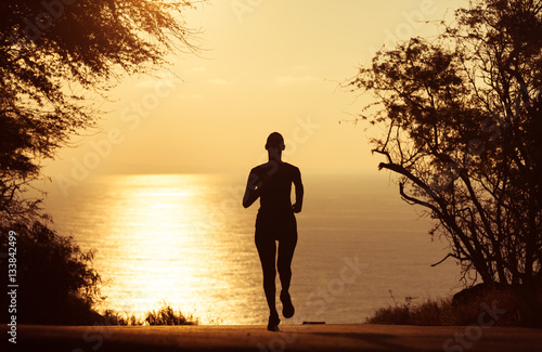 Silhouette of woman running in the sunset. 