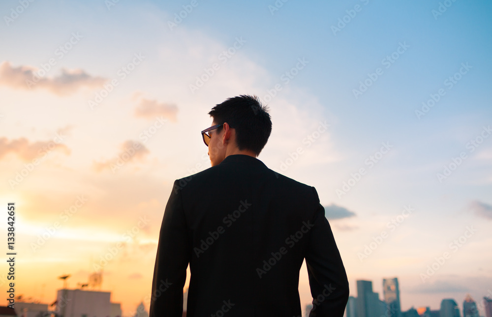 Young businessman walking in the city at sunset.  People success and life goals.  