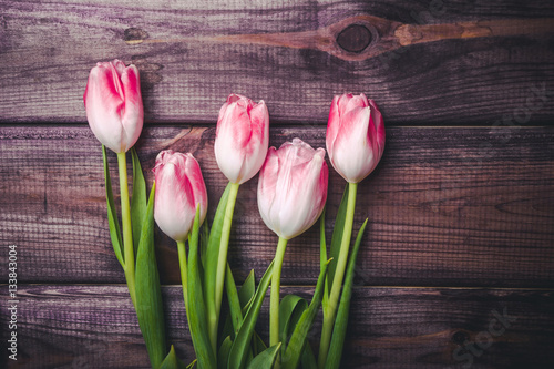 White and pink tulips on wooden table valentine background.