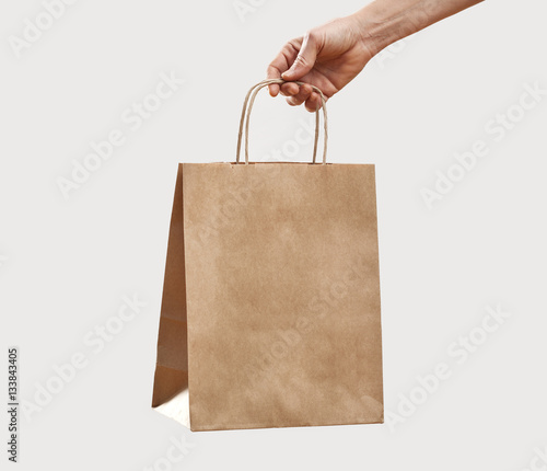Woman holding paper shopping bag on gray background