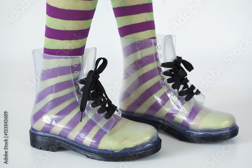 Woman stands with gumboots on white background