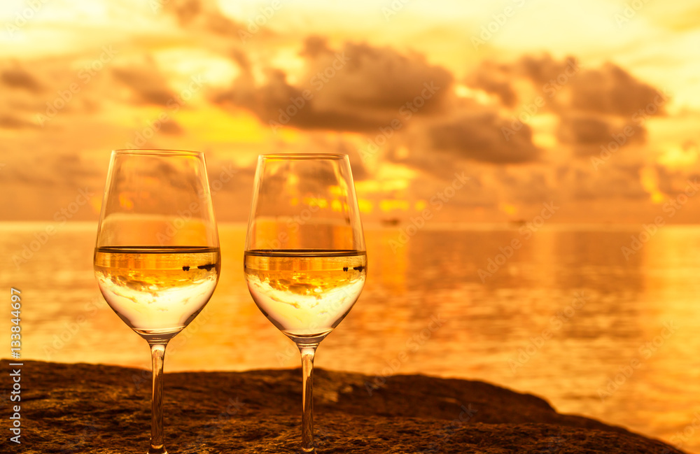 Wine glasses in a romantic setting by the sea. 
