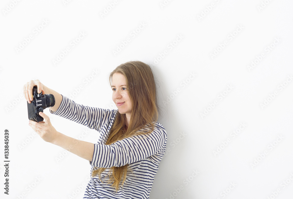 Young pretty girl taking picture of herself - selfie - with vintage camera on white background. Young pretty girl taking picture of herself - selfie - with vintage camera on white background.