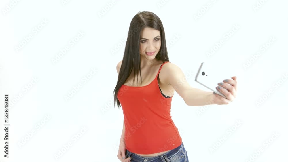 Brunette girl model makes selfie photo on the mobile. Studio Brunette girl model makes selfie photo on the mobile. Studio