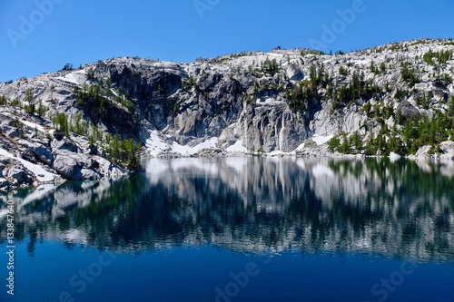 Granite rocks and reflections in calm water. Lake Vivian. The Enchantments. Cascade Mountains. Seattle. Leavenworth. WA. United States.