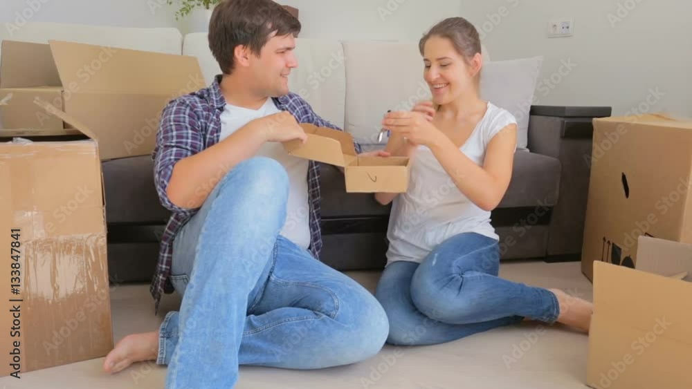 Young man giving box with keys from new apartment to his wife Young man giving box with keys from new apartment to his wife
