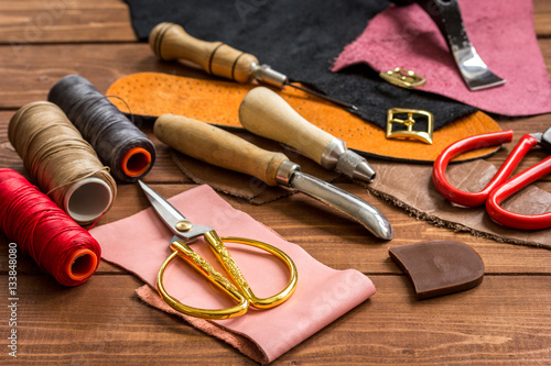 leather craft instruments on wooden background close up