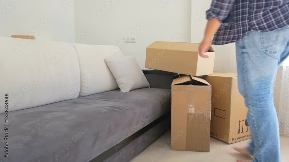 Young couple carrying packed cardboard boxes while moving to a new house Young couple carrying packed cardboard boxes while moving to a new house