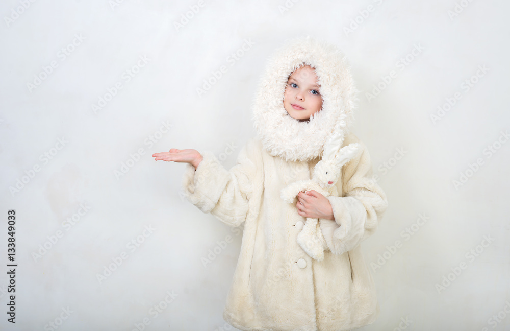 Beautiful little girl in winter clothes with a toy rabbit. Beautiful little girl in winter clothes with a toy rabbit.