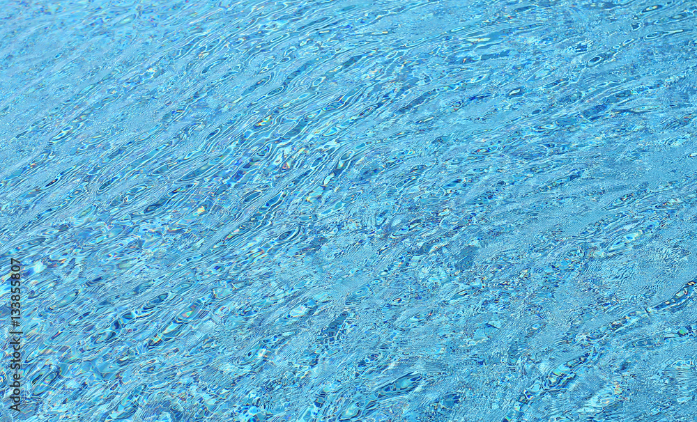 Water ripples on blue tiled swimming pool background