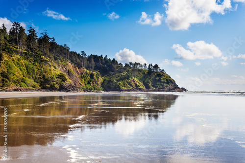 The Cape Disappointment end of Long Beach, Washington with the cliffs reflected in wet sand photo