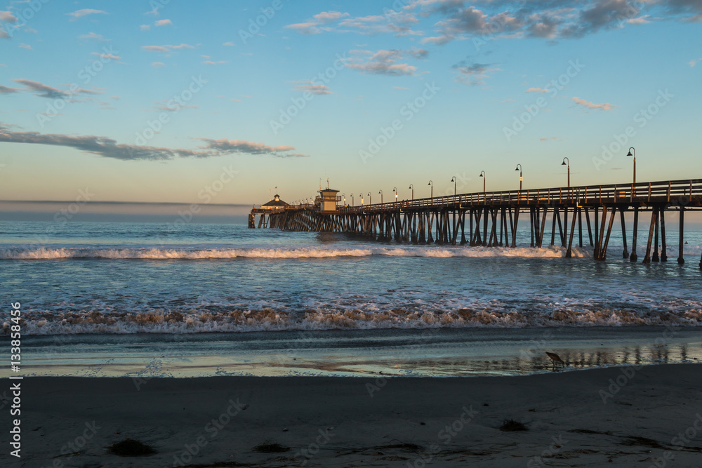 Imperial Beach fishing pier at dawn with beach in foreground in San Diego, California.