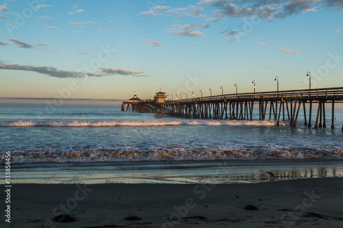 Imperial Beach fishing pier at dawn with beach in foreground in San Diego, California.