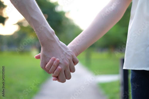 loving couple holding hands while walking at the park
