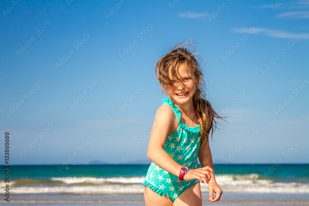 young happy child girl having fun on sand beach, sea background young happy child girl having fun on sand beach, sea background