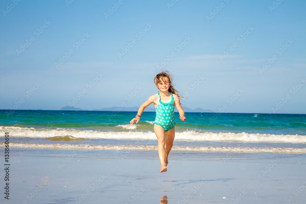 young happy child girl having fun on sand beach, sea background young happy child girl having fun on sand beach, sea background