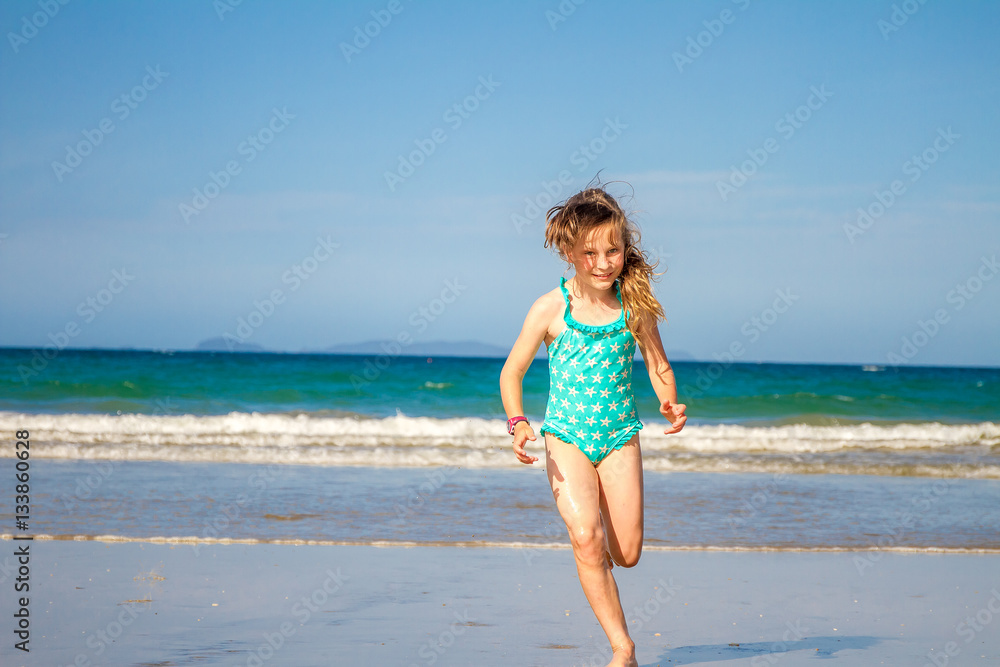 young happy child girl having fun on sand beach, sea background young happy child girl having fun on sand beach, sea background