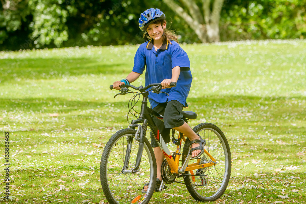 young happy preteen child boy riding a bicycle on natural park b